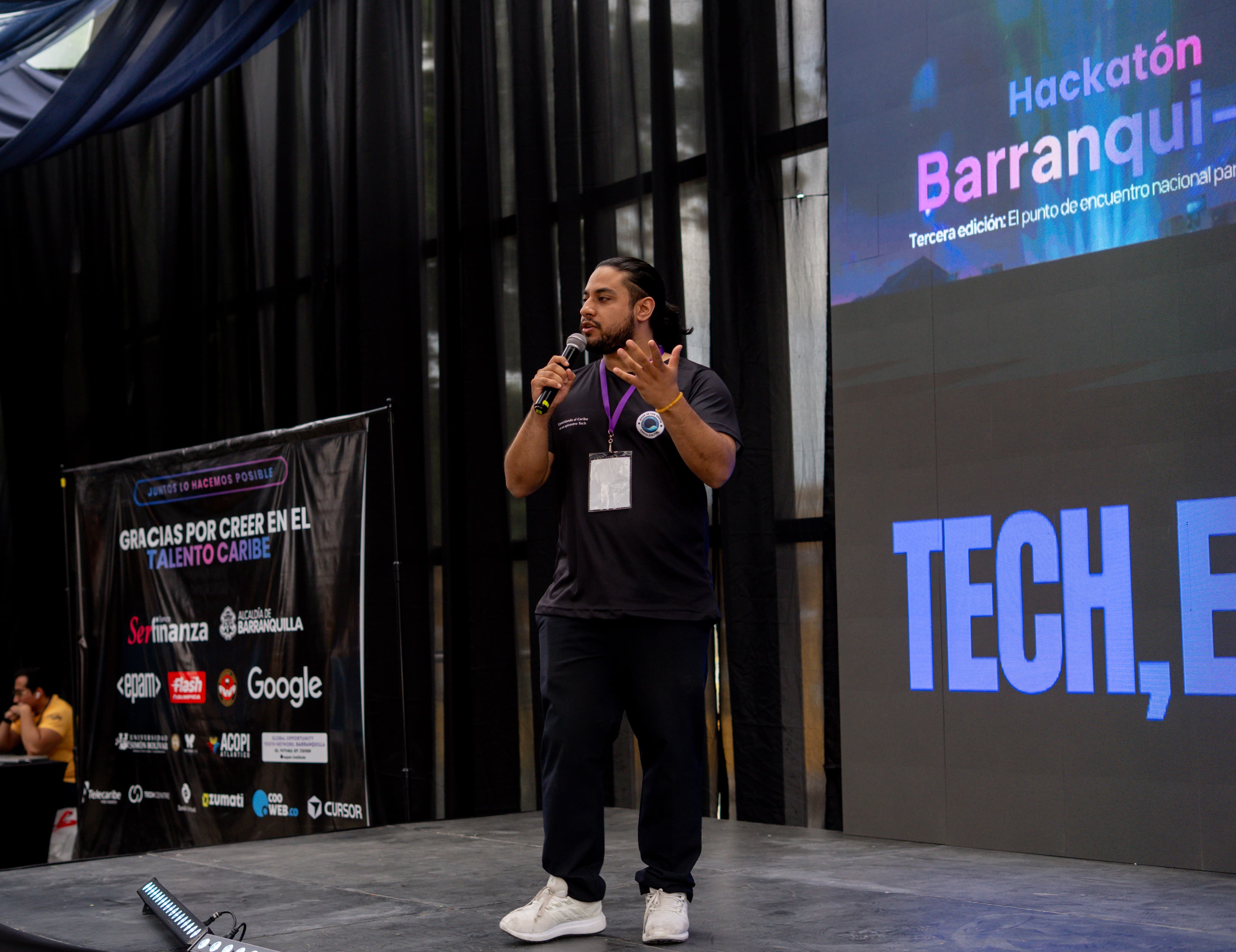 Anuar Harb dando una charla en un auditorio lleno.